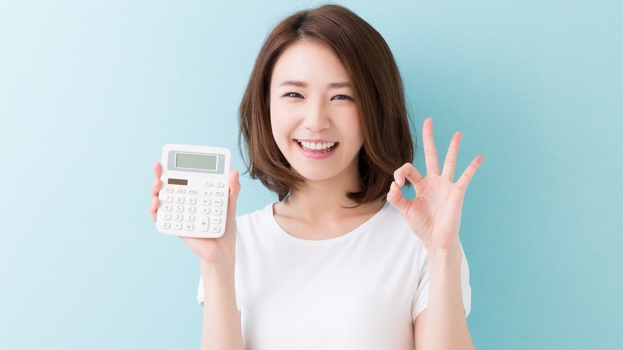 電卓を持った笑顔の女性